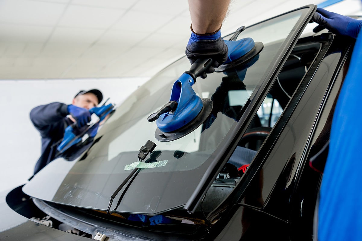 Mitarbeiter des Autohaus Sedlmaier tauschen eine Windschutzscheibe nach Glasschaden aus